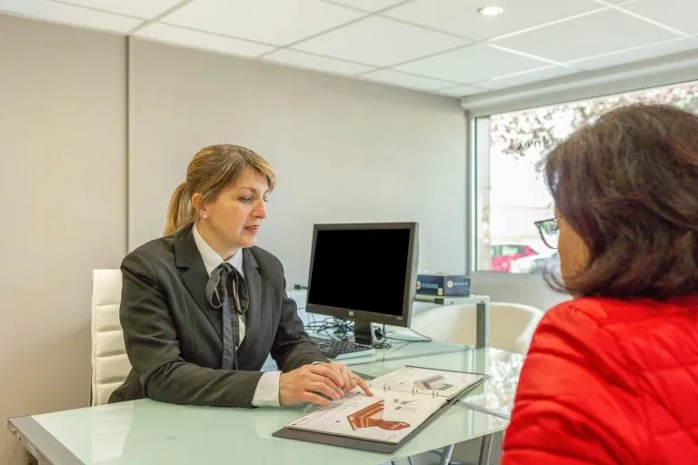 Conseillère funéraire présentant un contrat d'obsèques et des modèles de monuments à une cliente